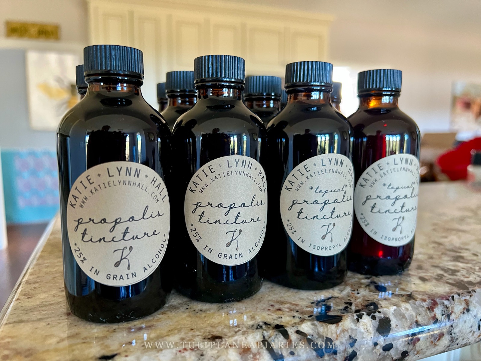 Amber bottles of propolis tincture on a granite counter